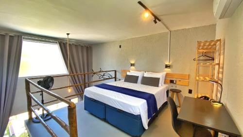 a hotel room with a bed and a balcony at LOFT Mar 101 - Com Piscina Privativa a Poucos Passos de Vilas Gastronômicas Polo de Artesanato e Associação Peixe-boi in Pôrto de Pedras