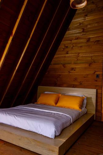a bed in a room with wooden walls at Glamping Entre Mangos in La Mesa