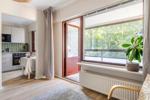 une cuisine avec une grande fenêtre et une table dans l'établissement Stylish marine studio, balcony, parking in Lauttasaari, à Helsinki