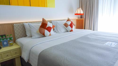 a bedroom with a large bed with red and white pillows at The Lantern Resorts Patong in Patong Beach