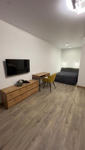 een woonkamer met een televisie, een bed en een tafel bij Sunset apart in Kremenets