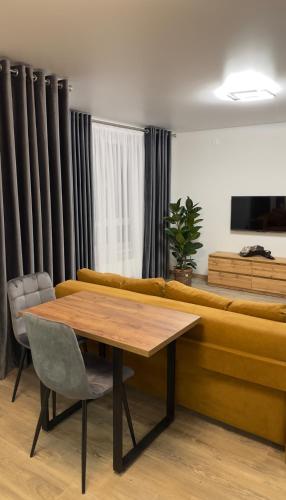 een woonkamer met een tafel en een bank bij Sunset apart in Kremenets