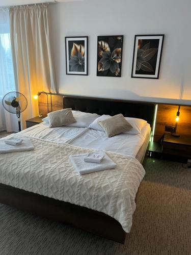 une chambre avec un grand lit avec des serviettes dessus dans l'établissement Apartament i pokoje Szalawa, à Kalisz