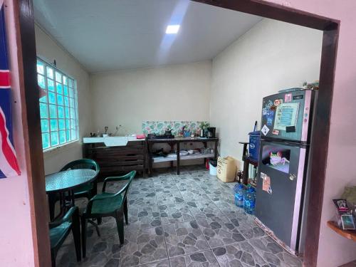 een kamer met een koelkast en een tafel en stoelen bij Casa Tuanis, Drake Bay in Drake