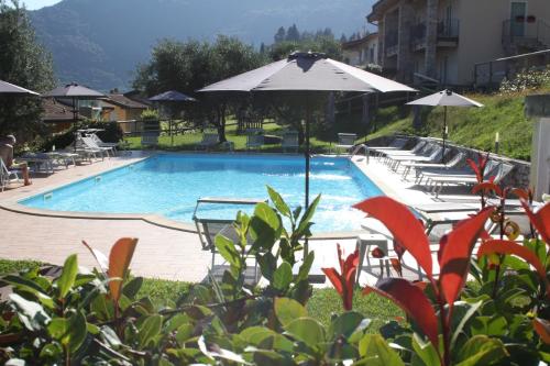 une grande piscine avec des chaises et un parasol dans l'établissement Casale di Pegol, à Tignale