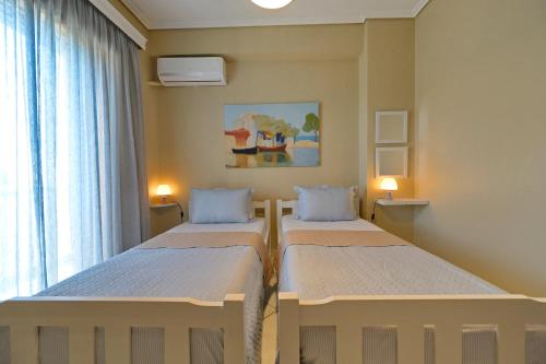 two beds in a small room with a window at Lidromi Home (Iris) in Patitiri