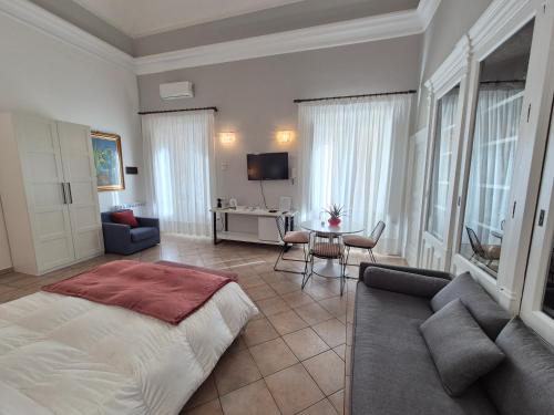 ein Schlafzimmer mit einem großen Bett und ein Wohnzimmer in der Unterkunft CENTRO STORICO HOME with terrace in Catania