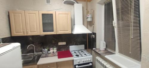 a small kitchen with a stove and a sink at Центр 2окремі кімнати балкон in Ivano-Frankivsʼk
