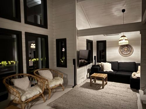 un soggiorno con un divano e una TV di Villa Laiskajaakko a Vimpeli