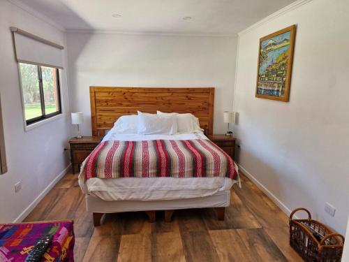 una camera da letto con un letto grande con testiera in legno di Oasis y canto de pájaros Piedra Colgada Copiapó a Copiapó