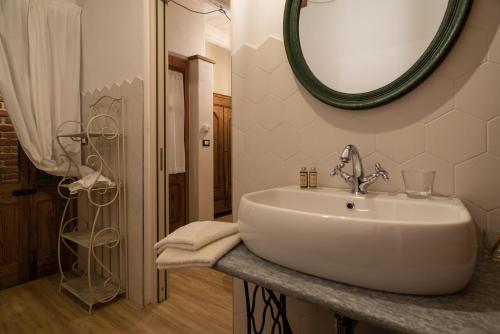 Un baño con un lavabo y un espejo en la pared. en Acini Sparsi, en Montalenghe