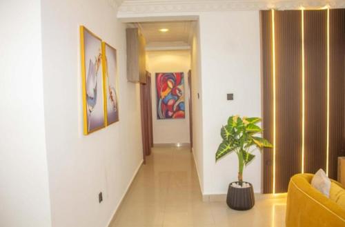 a hallway with a living room with a potted plant at Epic Apartment in Abuja