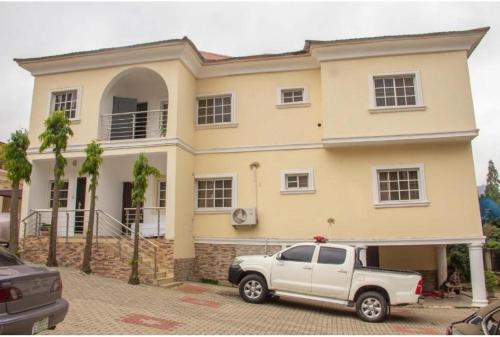 a white truck parked in front of a house at Epic Apartment in Abuja