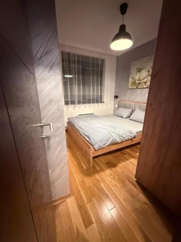 Un dormitorio con una cama y una ventana y una puerta. en Diamond grey Titova Vila, en Zlatibor