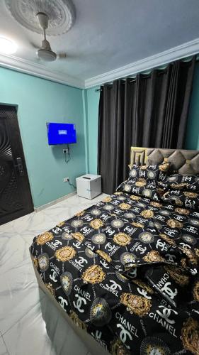 Un dormitorio con una cama con un edredón negro. en Prof's Villa, en Kumasi