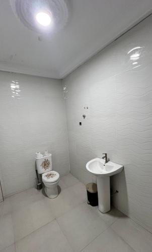 un baño con inodoro y lavabo en Prof's Villa, en Kumasi
