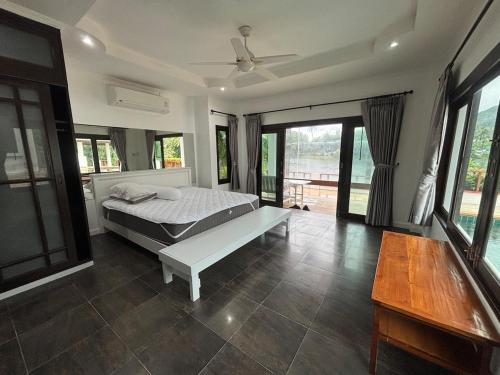 una camera da letto con un letto, un tavolo e finestre di Tropical Lakeview Villa I Bangtao Beach a Ban Lum Fuang