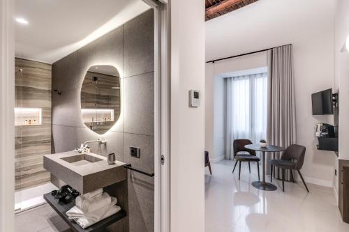 a bathroom with a sink and a table at Residenze Piazza Dante in Naples