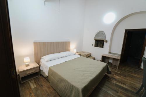 a bedroom with a bed and two night stands and a mirror at Agriturismo Marzilio in Ficarra