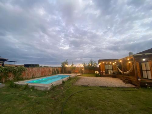 巴沙马拉尔Cabaña chapadmalal Nuestro rancho的带游泳池和房子的后院