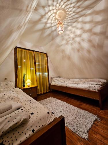 a bedroom with two beds and a chandelier at Vila Sreća - Kolašin in Kolašin