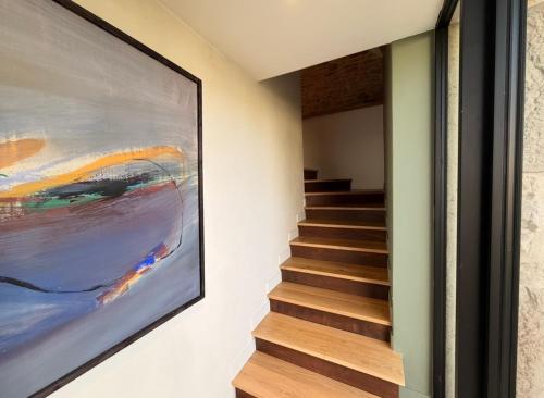 una escalera en una casa con una pintura en la pared en Les Terrasses de MAJORAC - Le Boudoir, en Bozouls