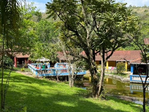 a blue boat on a river next to some trees at Espaço Krisalys in Guararema