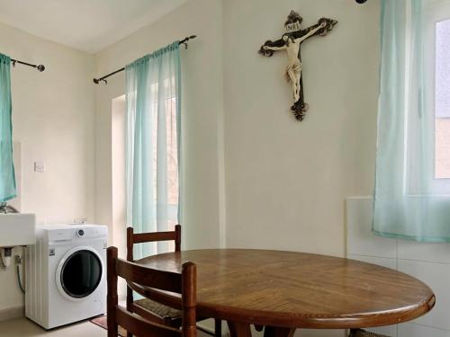 a dining room with a table and a cross on the wall at Traditional House of Character - 6 Guests Max in Rabat