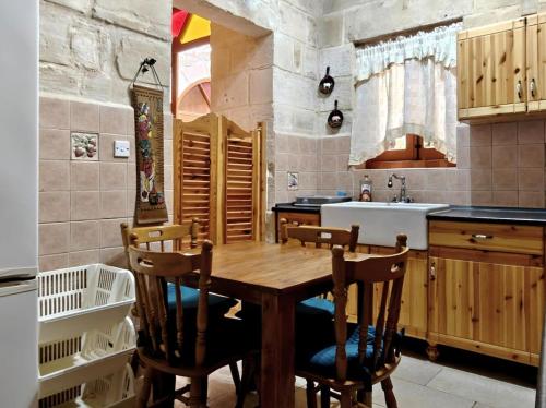 a kitchen with a wooden table and chairs at Traditional House of Character - 6 Guests Max in Rabat