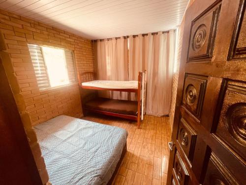 a small room with a bed and a window at Chácara Com Piscina e Vista das Montanhas in Atibaia