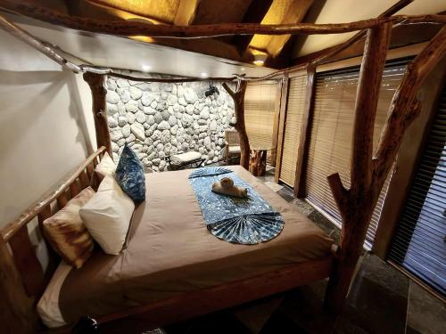 1 dormitorio con 1 cama en una habitación con un árbol en Aitutaki Escape, en Arutanga
