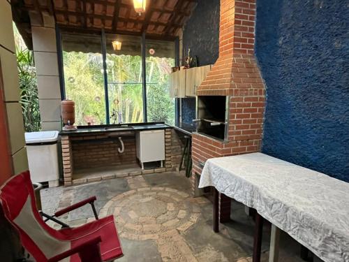 a kitchen with a brick oven and a table and chair at Espaço Krisalys in Guararema