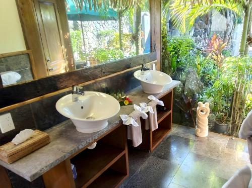 Un baño con dos lavabos y un espejo. en Aitutaki Escape, en Arutanga