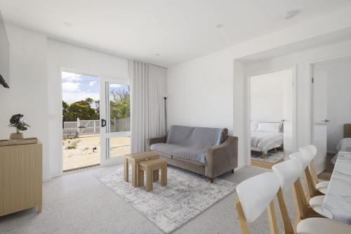 a white living room with a chair and a bed at Peaceful 2-Bed Apartment in Coastal McCrae in McCrae