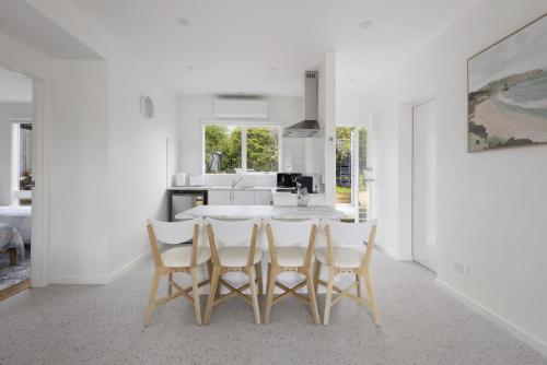 a white kitchen with a table and four chairs at Peaceful 2-Bed Apartment in Coastal McCrae in McCrae