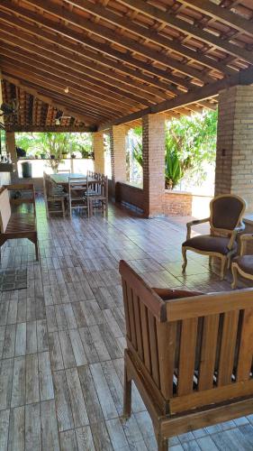 a porch with a bench and a table and chairs at Chalés Chácara Santa Felicidade 4 in Olímpia
