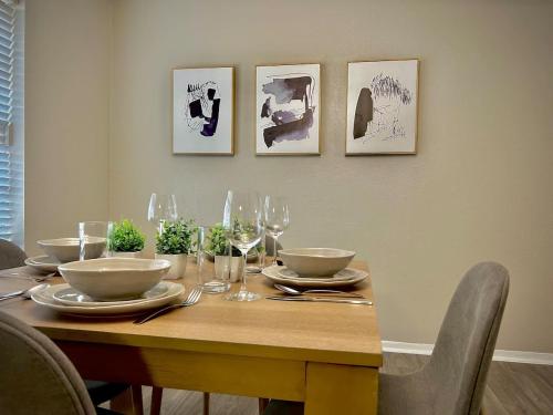 a dining room table with plates and wine glasses at Cozy Quiet LongStayDiscount A plus Location byChoctaw in Durant
