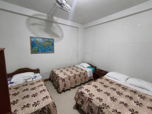 una stanza con due letti e un dipinto sul muro di Hospedaje Don Marco a Puerto Maldonado