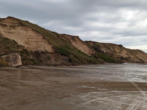 una spiaggia con una scogliera rocciosa e l'oceano di 8 person holiday home in Løkken-By Traum a Nørre Lyngby