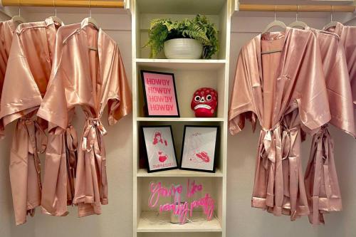 CaleraFuN FABulous KINGbed by ChoctawCasino LakeTexoma的房间里有个架子，上面挂着粉色的窗帘和照片。