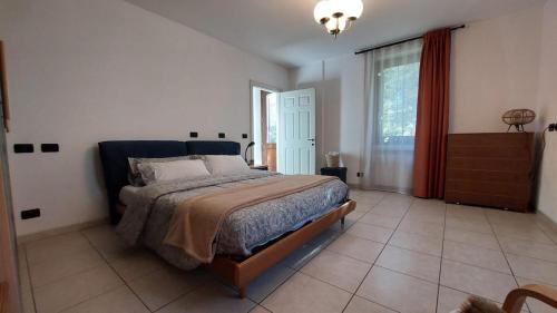 a bedroom with a bed and a large window at Valtellina home in Grosotto