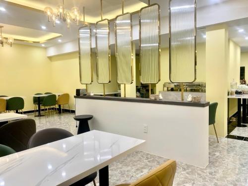 um restaurante com mesas, cadeiras e espelhos em Hali Hotel Da Lat em Da Lat