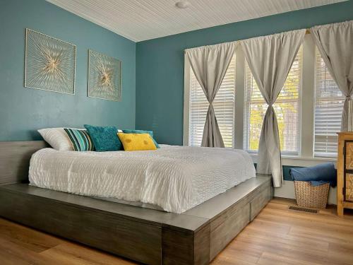 Schlafzimmer mit einem Bett mit blauen Wänden und Fenstern in der Unterkunft Gorgeous loft downtownSherman washer dryer WiFi in Sherman