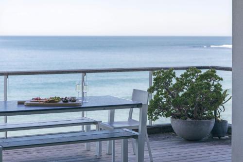 a table and chairs on a balcony with the ocean at ON THE Rocks - Yamba's Ultimate Absolute Beachdirft Residence - Holiday Yamba in Yamba