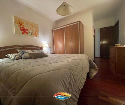 a bedroom with a large bed with a wooden headboard at Quiaios Beach House in Quiaios