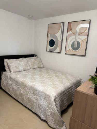 Cozy Studio Next To TPA Airport في تامبا: غرفة نوم بسرير وصورتين على الحائط