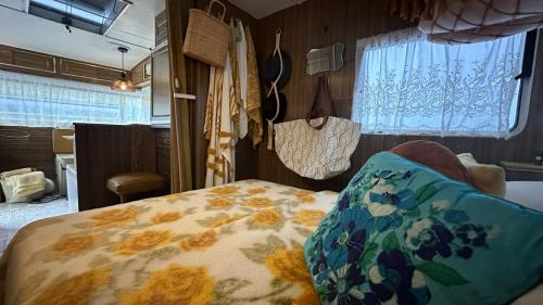 a bedroom with a bed with a flowered blanket at Australian Retro Beach stay in Rye