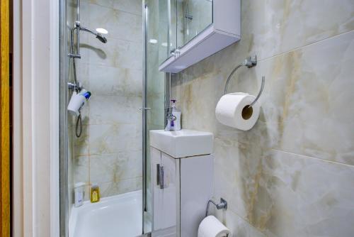 um banheiro com chuveiro, pia e vaso sanitário em London Residence Hotel em Londres