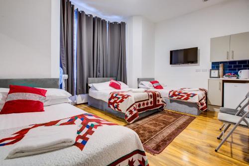 a hotel room with two beds and a television at London Residence Hotel in London