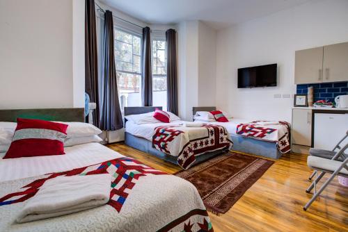 a hotel room with two beds and a tv at London Residence Hotel in London